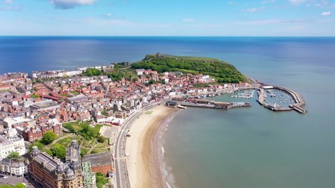 Aerial footage of the beautiful seaside coastal town of Scarborough in the North Yorkshire area in the UK England, showing the beach, harbour and 12th-century historic old Scarborough Castle