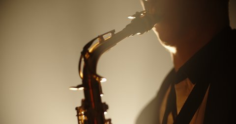 Cool saxophonist wearing a suit and performing an amazing solo. Musician doing a concert with jazz band - music, arts concept 4k footage