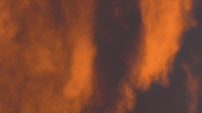 Vertical video yellow-orange clouds glowing by disappearing rays at sunset floating across dramatic dark purple and violet thunderclouds in sky to change weather. Summer natural meteorology background