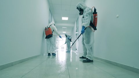Cleaners disinfect a hallway in office building to kill coronavirus.