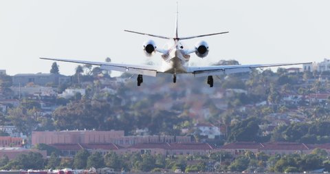 San Diego, California, USA, 2019. 4K footage of the small private jet landing on the busy runaway strip. Passenger transportation video. Exclusive top back view on the International airport.