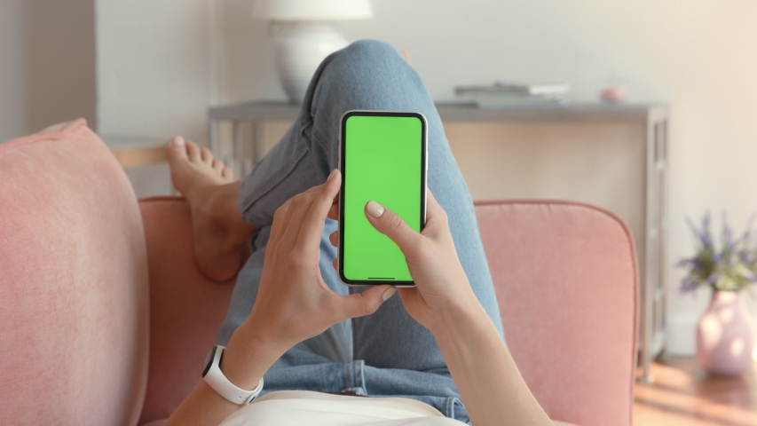 Phone with Green Screen and Chroma Key for Copy Space. Chromakey Mockup with Tracking Markers and Alpha Matte. Casual Lifestyle and Leisure on Comfortable Sofa. Swipe Left and Tap on Centre Close Up Royalty-Free Stock Footage #1052618651