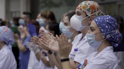 MADRID, SPAIN - APRIL 22 2020. Medical staff from Fundacion Jimenez Diaz hospital who are fighting coronavirus applaud back the people of Madrid and police officers for their support