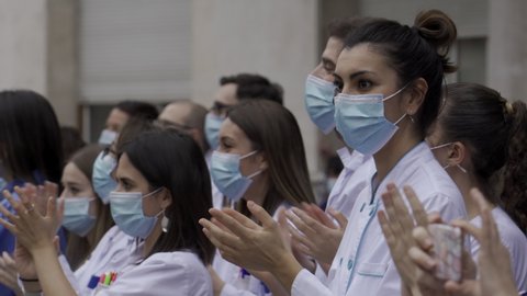 MADRID, SPAIN - APRIL 22 2020. Medical staff from Fundacion Jimenez Diaz hospital who are fighting coronavirus applaud back the people of Madrid and police officers for their support