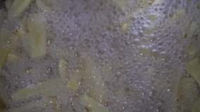 Making of jackfruit chips. Deep frying slices of jackfruit flesh in coconut oil.
