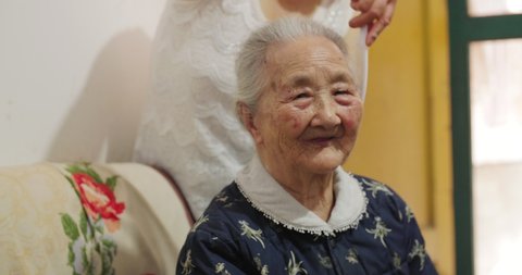 Close up of family member take care of senior grandmother at home happy senior asian woman close up long-lived healthy Chinese old people indoor 4k clip