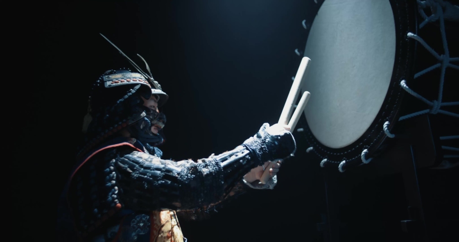 Asian man in historical samurai costume playing taiko drum, isolated on black background - tradition, history, culture concept close up 4k footage
