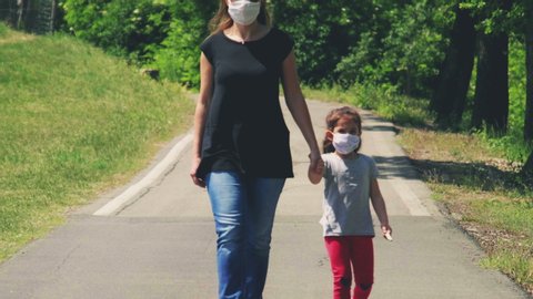 coronavirus new normal family life - woman child face mask walk on empty road after covid .