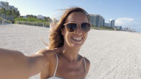 Selfie happy woman in Miami Beach enjoying vacations video sharing online while traveling in Florida 