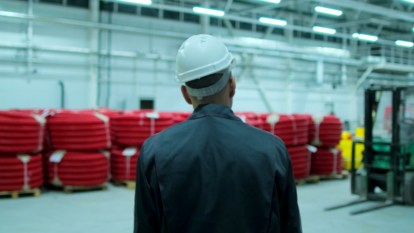 Follow footage of asian employees male warehouse worker engineer in hard hat working, walking through logistics center warehouse factory construction site architect businessman man indoors, slowmo 4 K Royalty-Free Stock Footage #1052653850