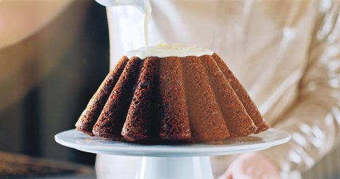 Slow motion of white cream pouring on a holiday chocolate cake