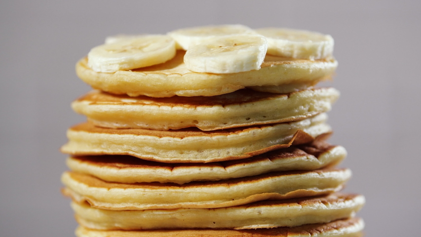 Pancakes with Chocolate Syrup, Nuts and Bananas. Stack of whole flapjack. Tasty breakfast and Healthy Food Royalty-Free Stock Footage #1052657885