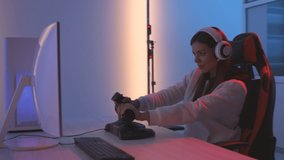 The gamer girl with headphones playing video games in the blue light studio