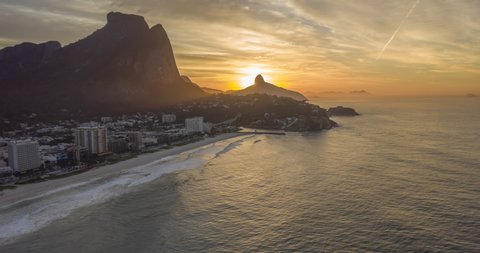 Aerial hyperlapse of sun rising behind the mountain with the sea of Rio de Janeiro