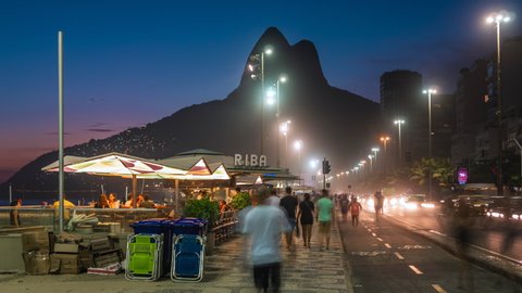 Rio de Janeiro, Brazil - November 22: Timelapse view of people walking on the iconic mosaic sidewalks along Ipanema Beach at night in Rio de Janeiro, Brazil.
