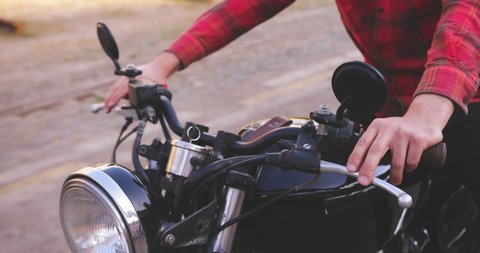 Close up of biker's hands on handle of classic motorcycle