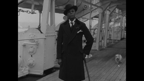 CIRCA 1930 - A well-dressed African-American man shows off his apparel on the deck of a nice ship.