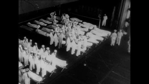 CIRCA 1945 - US Navy sailors are buried at sea after a kamikaze attack on the USS Bunker Hill.