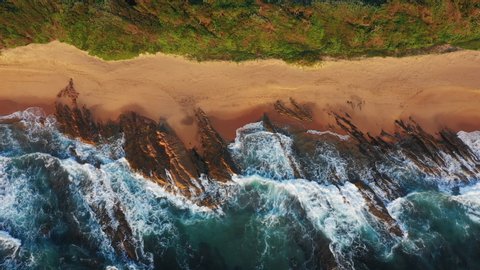 Aerial Drone Shot of South African Coastline at Sunrise. Beautiful Ocean Coastline with Waves Crashing on Beach
