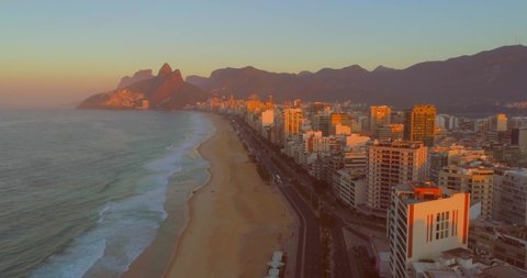 Rio de Janeiro sunrise past buildings on ipanema beach with mountains in the background
