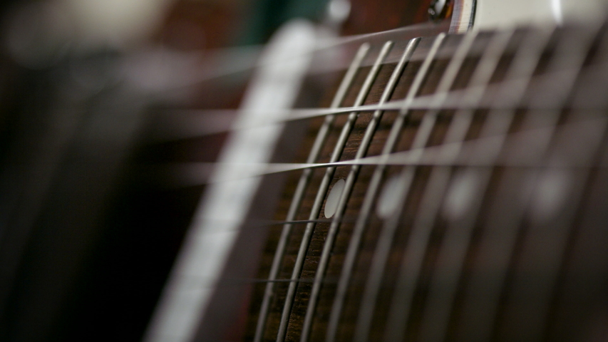 Playing the guitar. Strumming electric guitar. A musician plays music. Shot on RED camera in 4k. Royalty-Free Stock Footage #1052695382