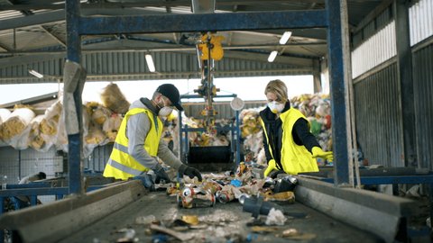 Man and woman workers on landfill, waste management and environmental concept.