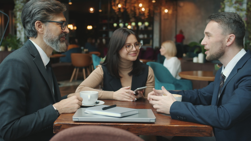 Business men in suits are talking discussing international deal with female interpreter then shaking hands in restaurant. Communication and talks concept. Royalty-Free Stock Footage #1052708114