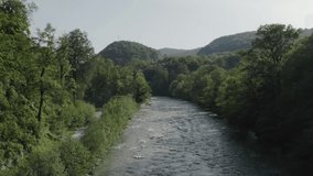 Beautiful views of the mountains and the river. Green trees. Aerial video. From a bird's-eye view. 
