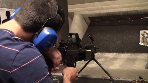 LAS VEGAS, NEVADA, USA - MAY 16 2020: Tourists & American civilians shooting an automatic machine gun in a gun store & firing range. M249 S.A.W & Semi-auto are legal weapons, NRA no background check