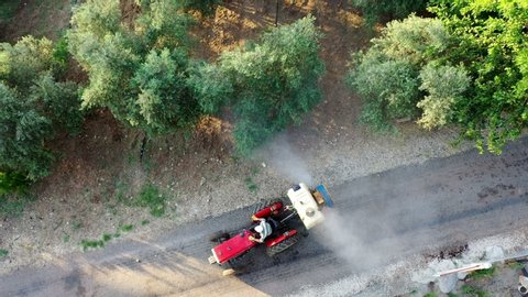 Garden spraying. olive-tree garden spraying insecticide with a tractor. Pest control. 4K Video / Aerial view with drone