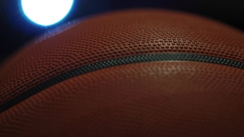 Cinematic Basketball Rotates In Dark Court Back-lighting.