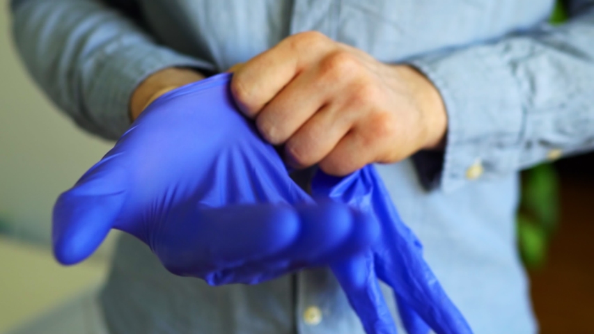 Man puts on his medical gloves. Covid-19 prevention. Royalty-Free Stock Footage #1052723849