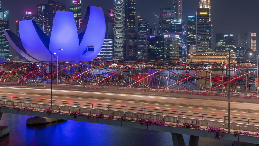 SINGAPORE - CIRCA JAN 2020: Aerial view over Helix Bridge and Bayfront Avenue with traffic day to night transition timelapse at Marina Bay from above with illuminated skyscrapers skyline on a | Shutterstock HD Video #1052727155