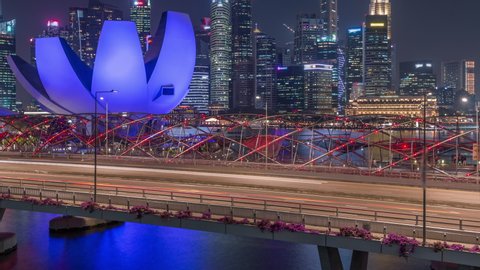 SINGAPORE - CIRCA JAN 2020: Aerial view over Helix Bridge and Bayfront Avenue with traffic day to night transition timelapse at Marina Bay from above with illuminated skyscrapers skyline on a