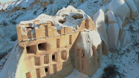 Aerial view of Pigeon Valley and cave houses covered with snow at the sunrise in Cappadocia, Turkey	