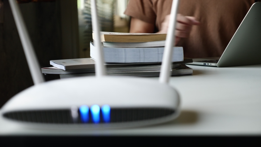 Close up of a wireless router and a man using laptop on the table Royalty-Free Stock Footage #1052728475