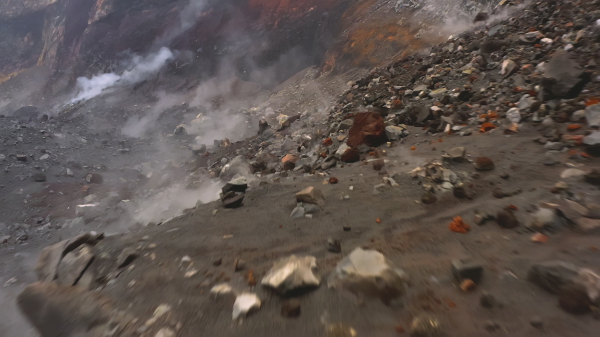 Close up of sleeping volcanic crater consisting of rocks, hardened lava and smoke. Close-up of steam coming through solid lava. Volcanic rocks inside crater in Volcano Royalty-Free Stock Footage #1052736893