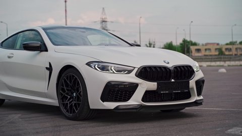 ROSTOV-ON-DON, RUSSIA - MAY 7, 2020: brand new matte white BMW M8 Competition Coupé sports car in empty car parking lot on cloudy day.