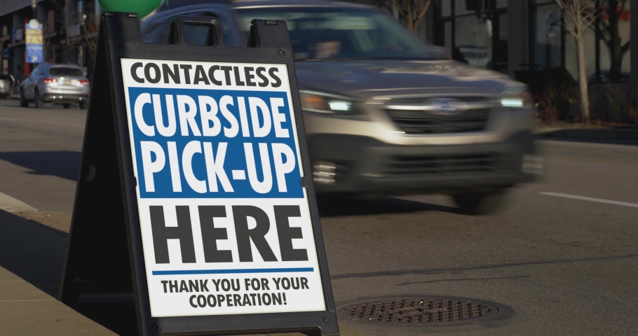 A sign in the business district of a large city shows the contactless pickup location. Take-out became the default way of business for restaurants during the Coronavirus outbreak of 2020.	 Royalty-Free Stock Footage #1052738180