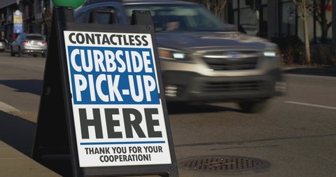 A sign in the business district of a large city shows the contactless pickup location. Take-out became the default way of business for restaurants during the Coronavirus outbreak of 2020.	