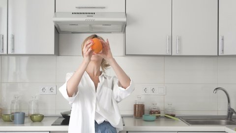 Funny young woman playing and dancing with fresh oranges, good morning mood