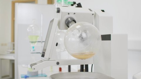 Close up of chemist extracting cbd with rotavapor in laboratory