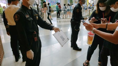 Security Guard at Mall Holding QR Code Which People Have to Scan With Smartphone for Contact Tracing Measures Against Coronavirus (Covid-19) in Bangkok, Thailand - May 2020