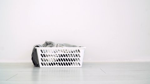 Dirty clothes falling into the laundry basket