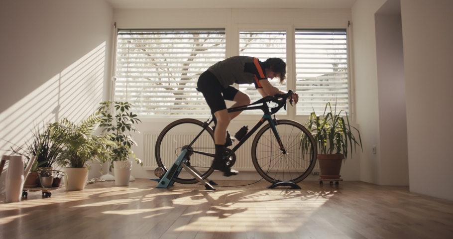 Man finish spinning home bicycle trainer training for the season staying at home | Shutterstock HD Video #1052755946
