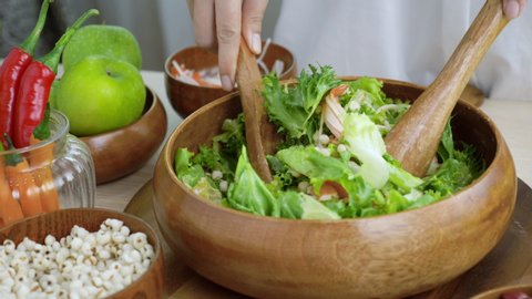 Hand woman chef Mixing Green Salad , Millet,Crab Stick In glass bowl. Breakfast fresh salad and clean vegetable can eat raw. Nutritious and enzymes in Salad mix leaves green vegetable can detox. 