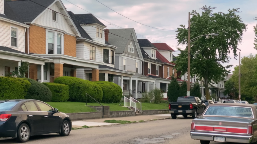 A daytime summer exterior establishing shot of typical rust belt middle class homes in a residential neighborhood of a small New England town. Pittsburgh suburbs.  	 Royalty-Free Stock Footage #1052762801