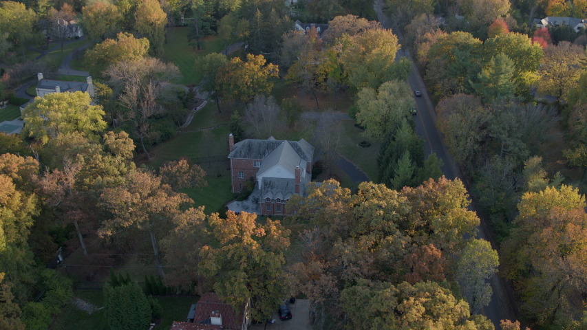 Flyover nice houses and tree lined road in St. Louis in Autumn at sunset
