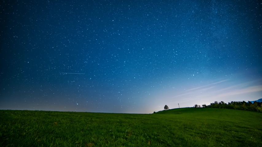Beautiful starry sky above the grassland at night. Time lapse