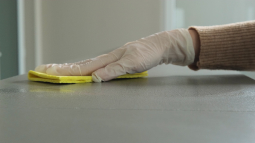 Hands in medical white gloves sprays disinfectant and wipe the surface with a yellow rag. Prevention and control of pandemic nCoV. Cleaning and disinfecting high-touch household surfaces | Shutterstock HD Video #1052779910